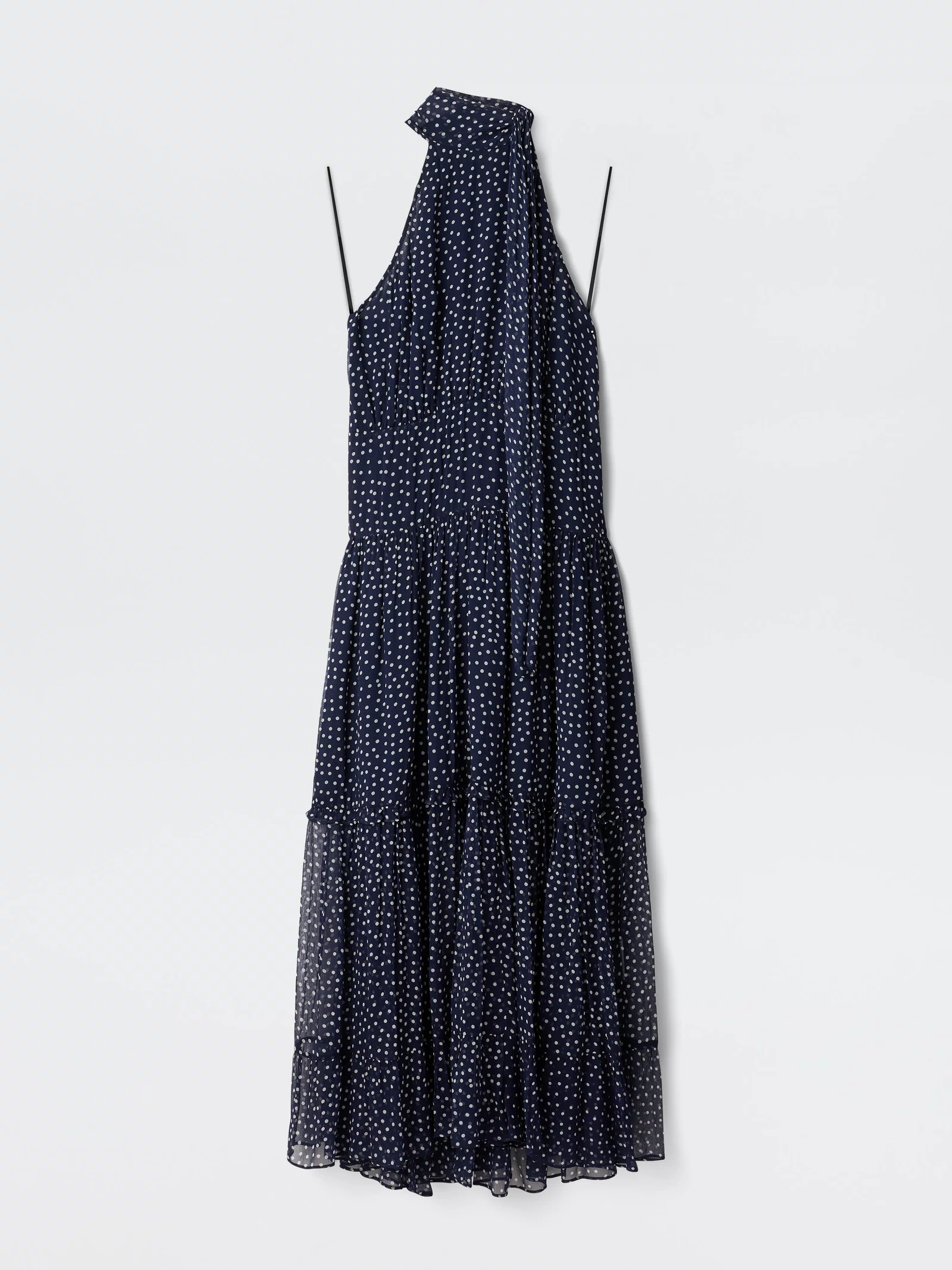The Abi - Mini Navy Polka Dot is a sleeveless navy georgette mini dress with white polka dots, thin straps, a halter neckline, and an attached scarf detail, shown against a plain white background.