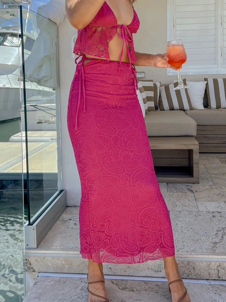 Rear-side view of a fuschia lace maxi skirt with adjustable tie-up sides and a subtle paisley pattern