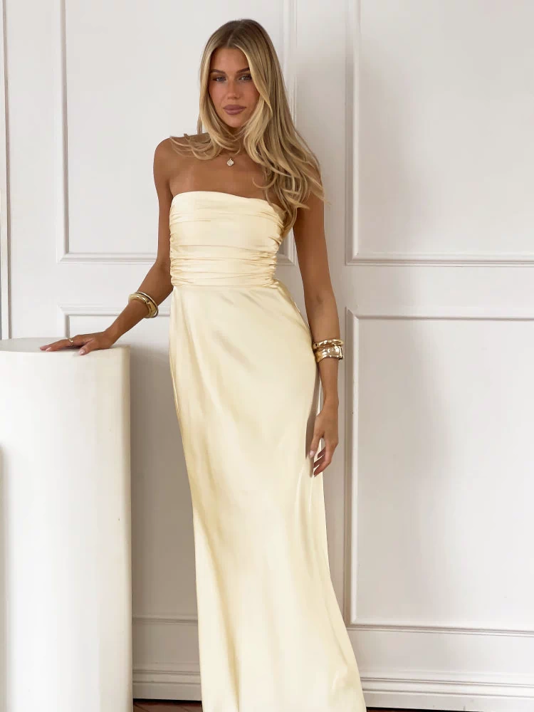 Front view of a pale yellow strapless maxi dress with a ruched bodice and a long, flowing skirt