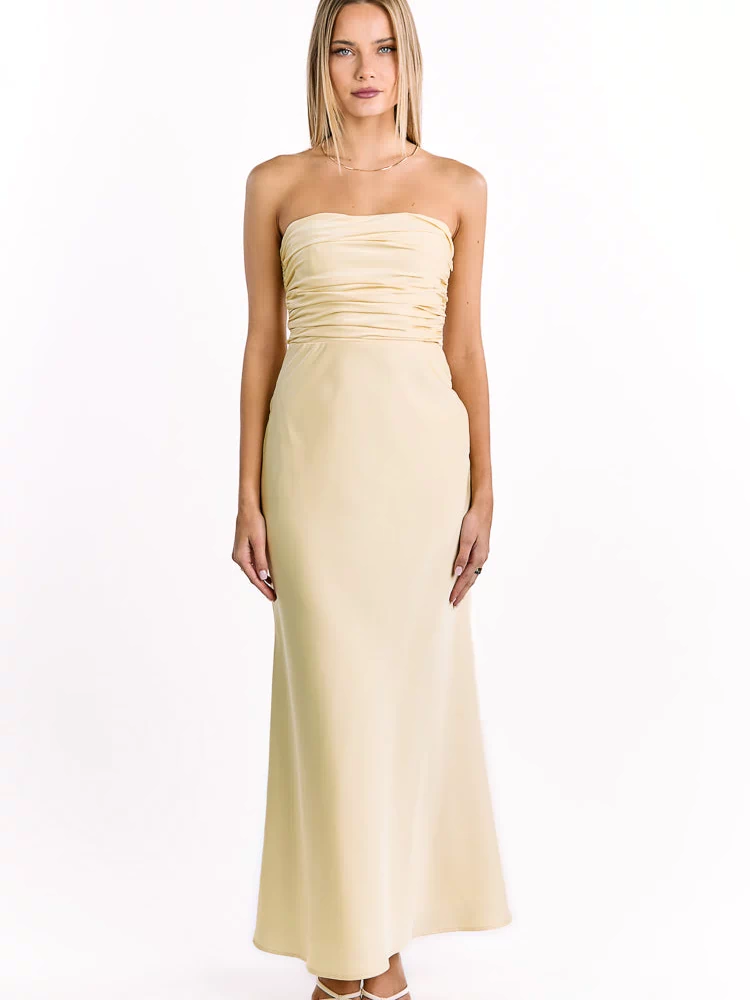 Pale yellow strapless maxi dress with a horizontally ruched bodice and a long, flowing skirt