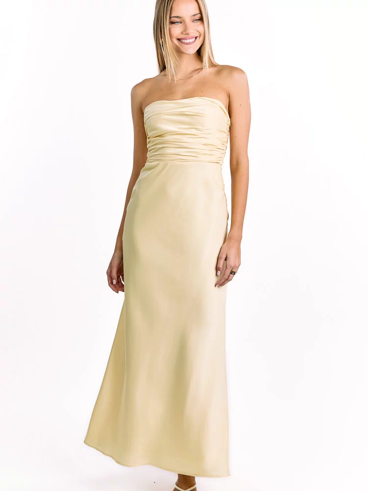 Front view of a pale yellow strapless maxi dress with a ruched bodice and a flowing A-line skirt