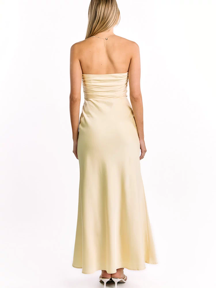 Rear view of a yellow strapless maxi dress with a ruched back bodice and flowy skirt