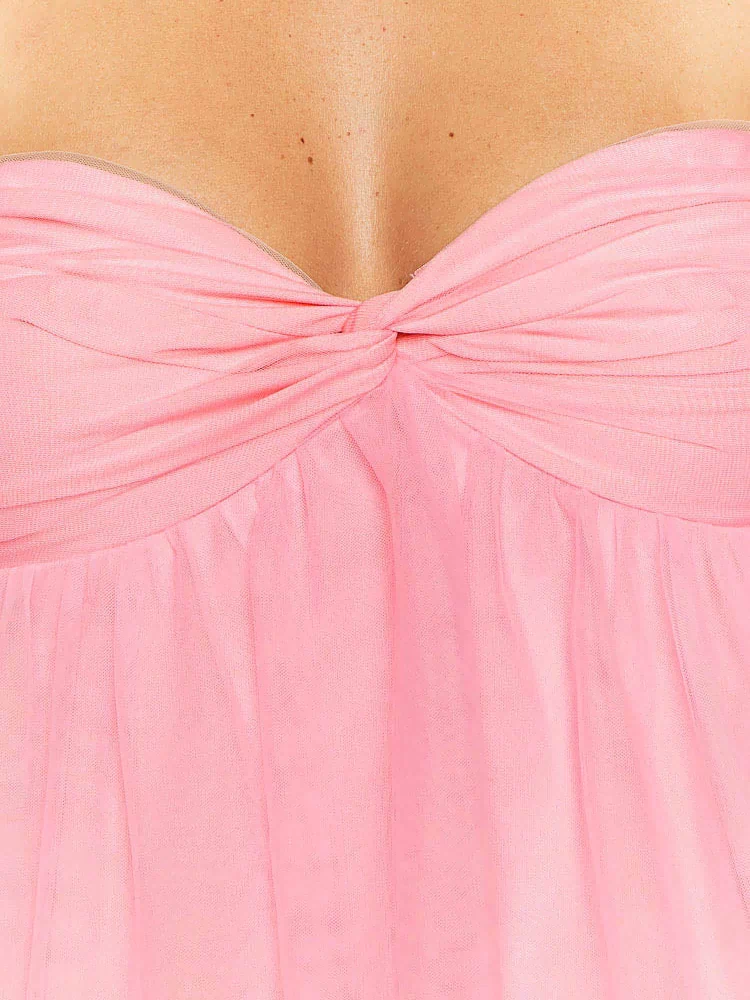 Close-up of the pink strapless mini dress showing the twisted knot bust detail and sheer ruched fabric