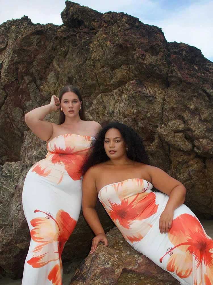 Two white strapless bodycon maxi dresses with vibrant orange and red hibiscus floral print