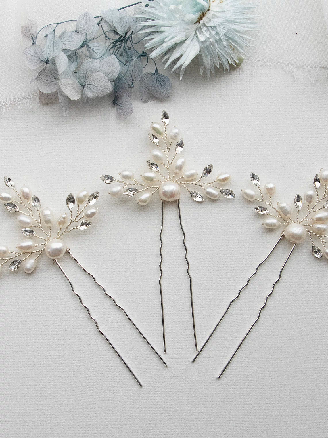 three hair pins with pearls and leaves on them