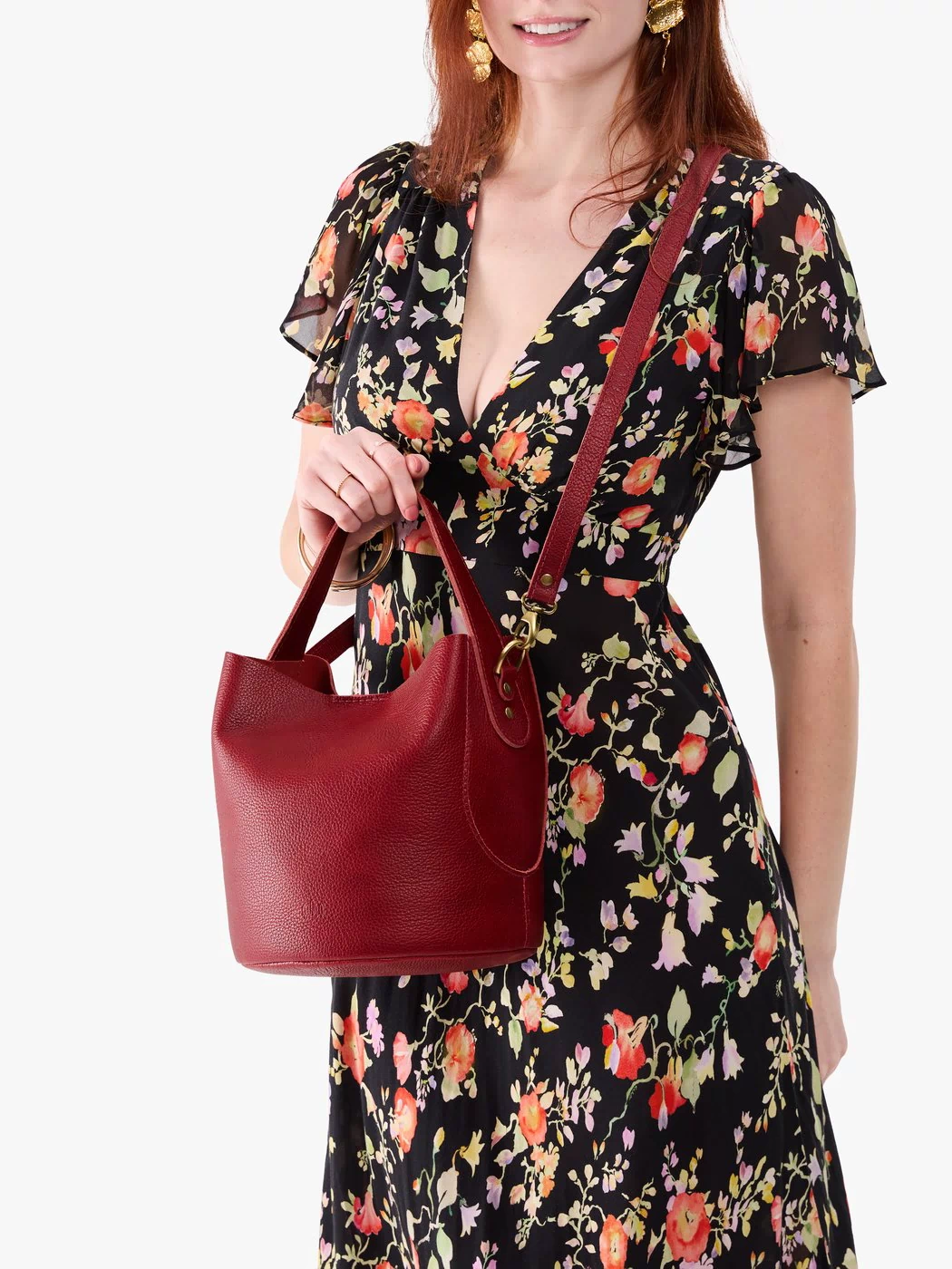 Chili Red*Large | Model holding symmetrical bucket bag with handle, latch closure, and removable crossbody strap