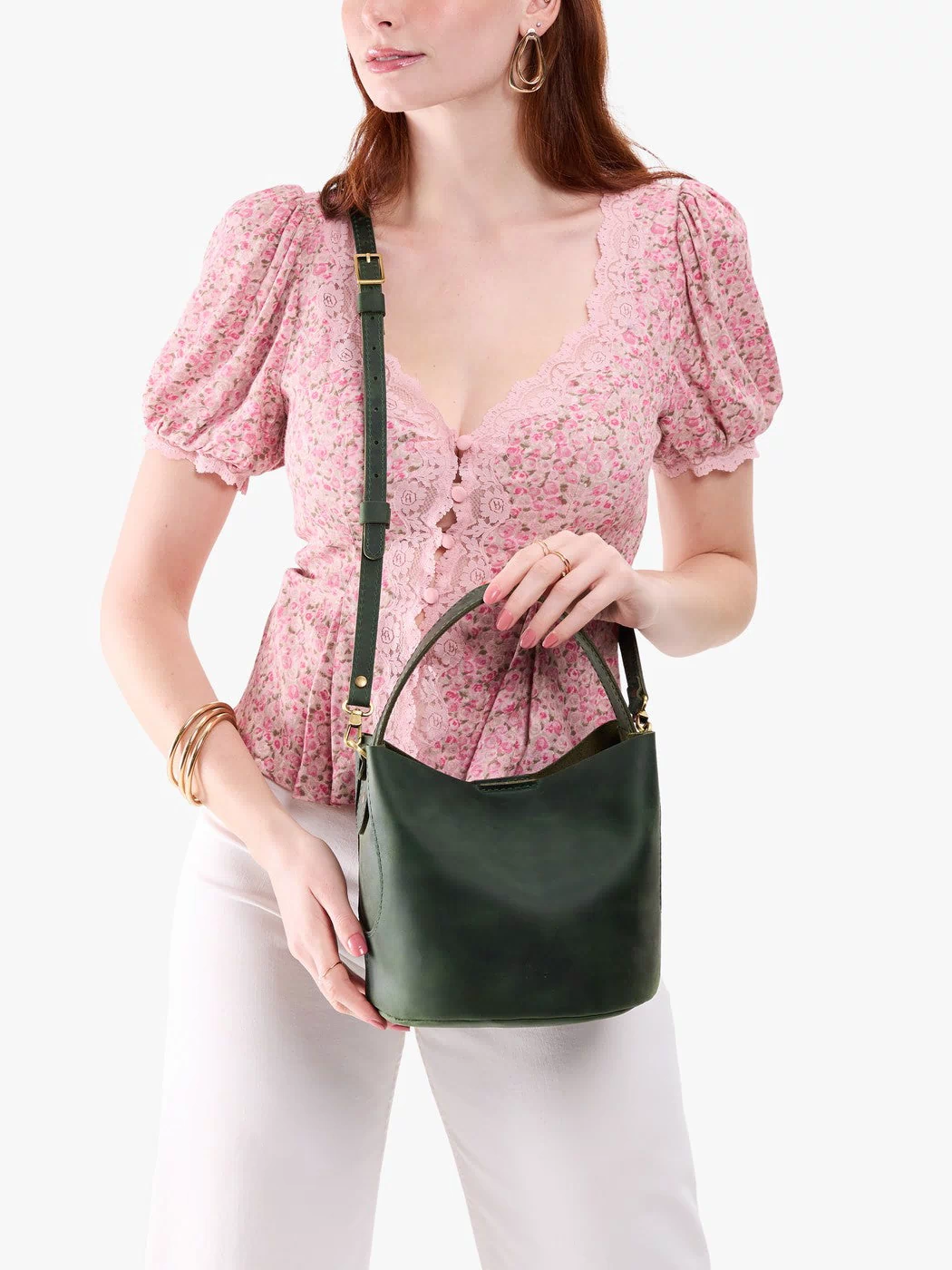 Evergreen*Small | Model holding symmetrical bucket bag with handle, latch closure, and removable crossbody strap