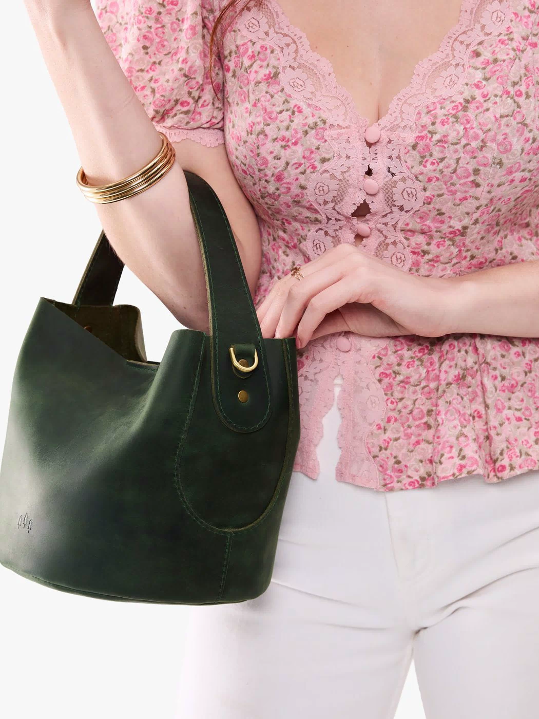 Evergreen*Small | Model holding symmetrical bucket bag with handle, latch closure, and removable crossbody strap
