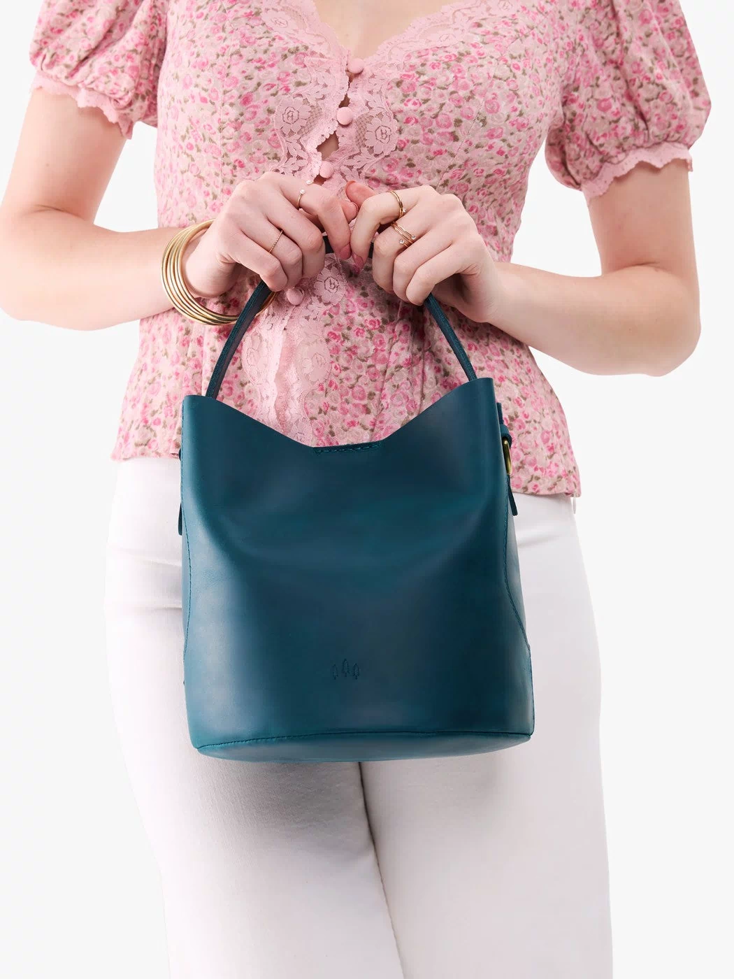 Westward Blue*Large | Model holding symmetrical bucket bag with handle, latch closure, and removable crossbody strap