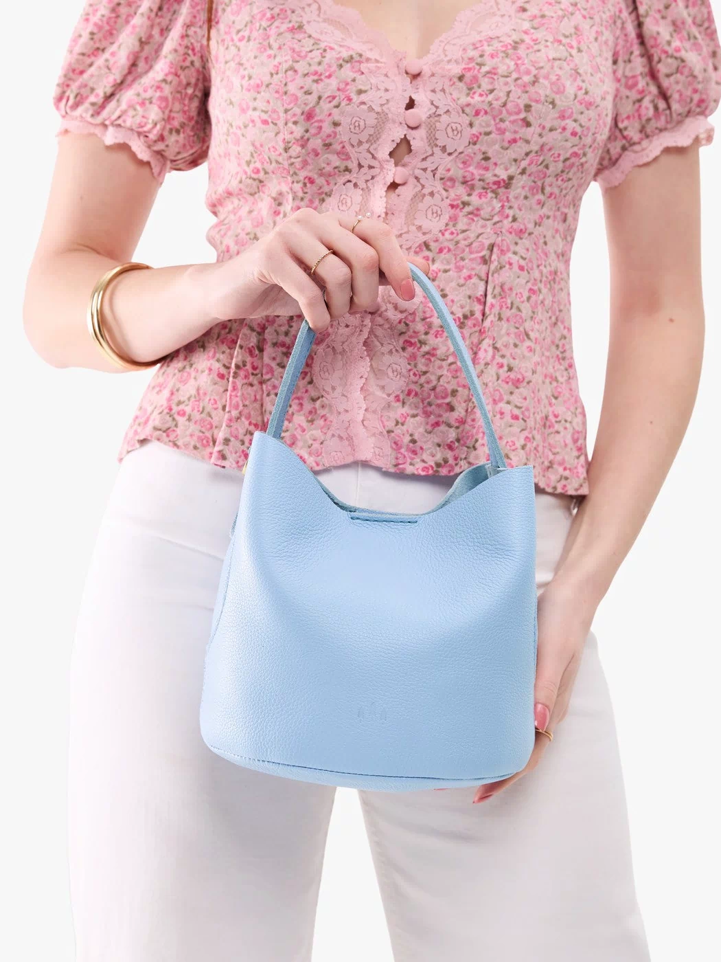 Skyway*Small | Model holding symmetrical bucket bag with handle, latch closure, and removable crossbody strap
