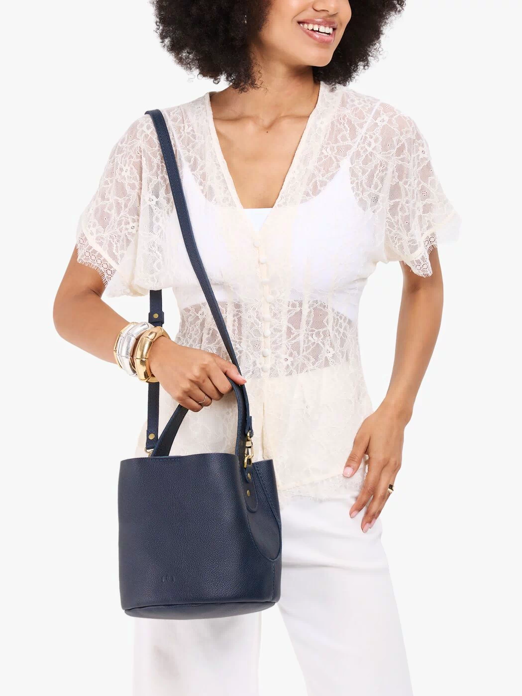 Night Owl*Small | Model carrying symmetrical bucket bag with handle, latch closure, and removable crossbody strap