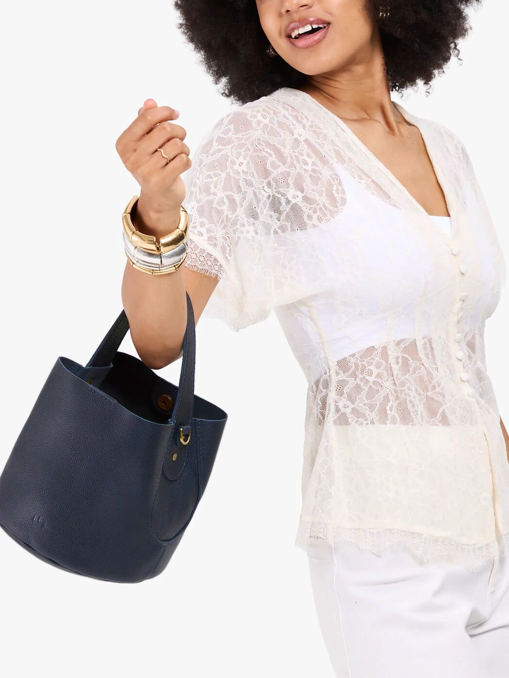 Night Owl*Small | Model carrying symmetrical bucket bag with handle, latch closure, and removable crossbody strap