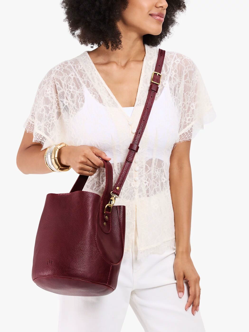 Cabernet*Large | Model carrying symmetrical bucket bag with handle, latch closure, and removable crossbody strap