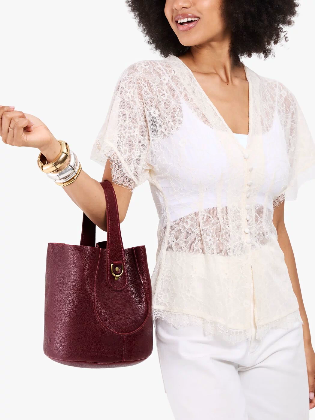 Cabernet*Large | Model carrying symmetrical bucket bag with handle, latch closure, and removable crossbody strap