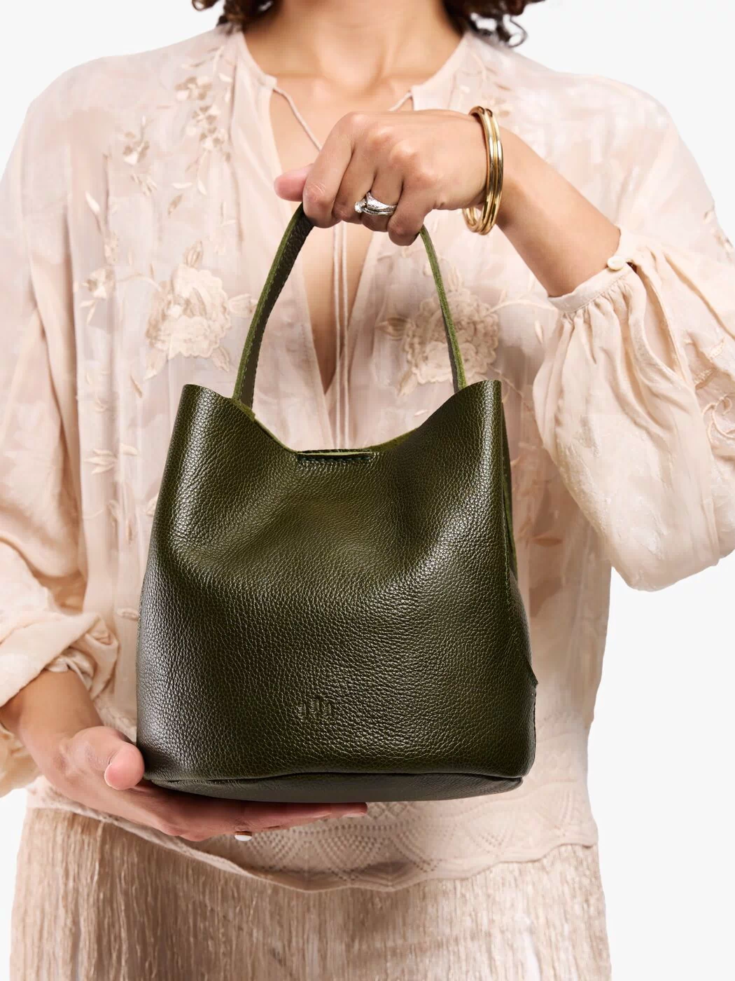 Pebbled Olive*Large | Model carrying symmetrical bucket bag with handle, latch closure, and removable crossbody strap