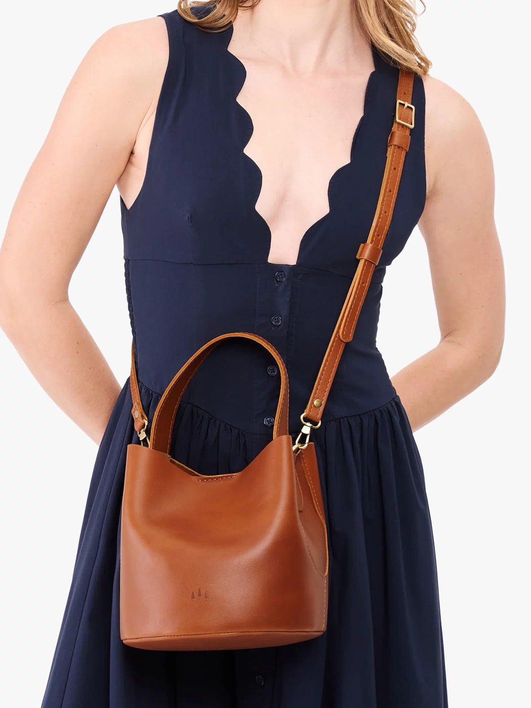 Honey*Small | Model wearing symmetrical bucket bag with handle, latch closure, and removable crossbody strap
