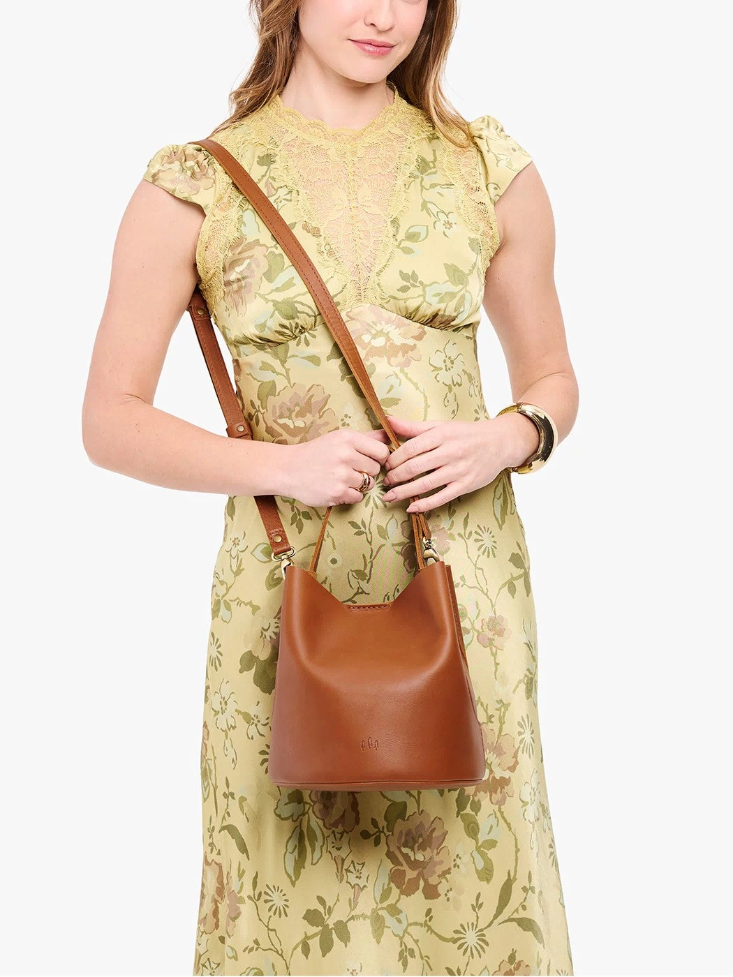 Honey*Large | Model wearing symmetrical bucket bag with handle, latch closure, and removable crossbody strap