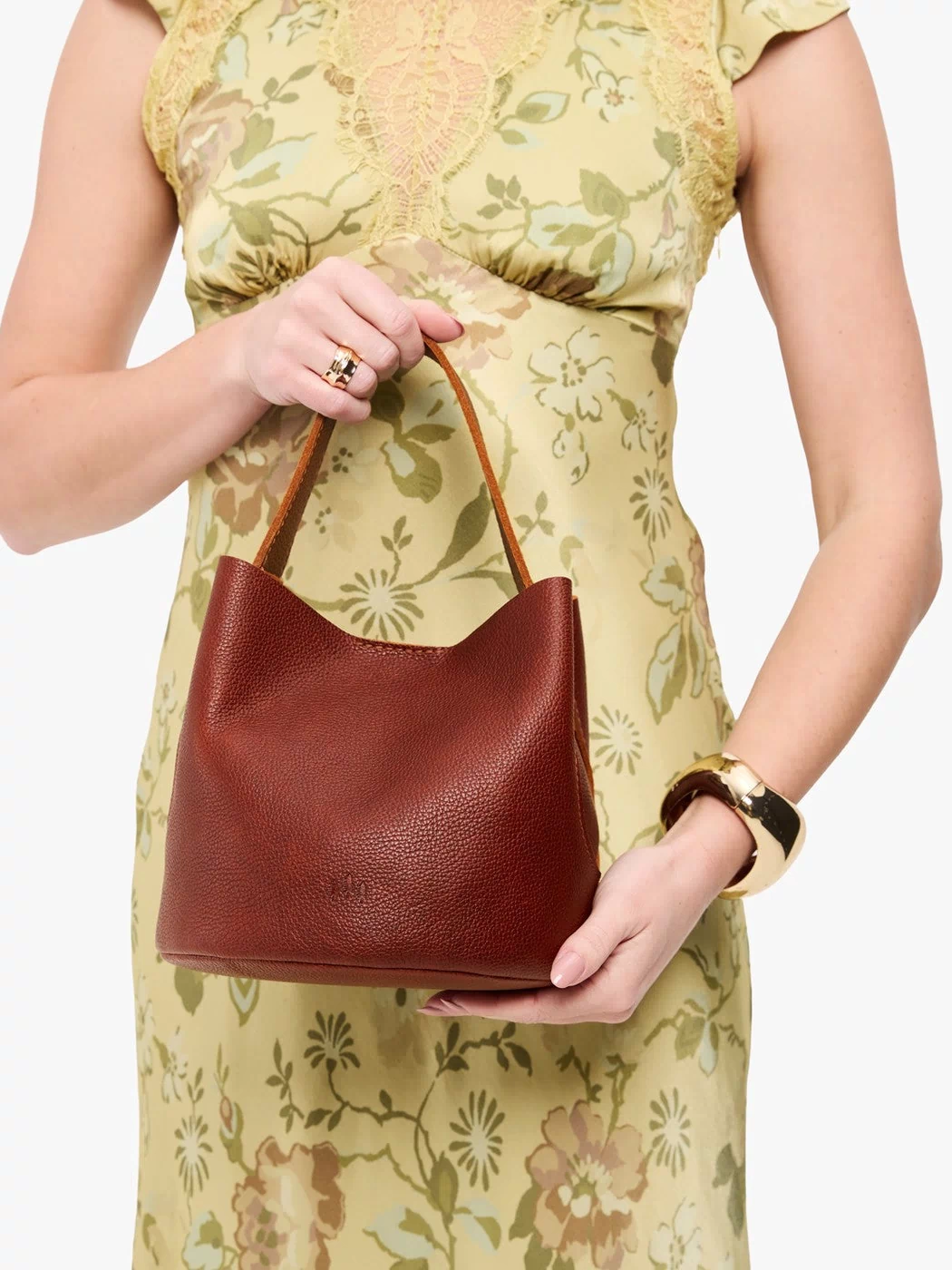 Nutmeg*Small | Model holding symmetrical bucket bag with handle, latch closure, and removable crossbody strap
