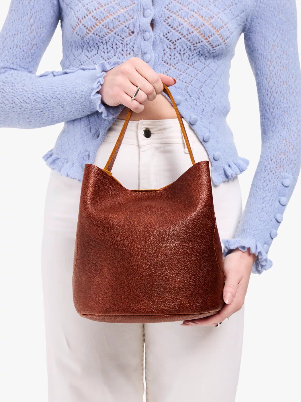 Nutmeg*Large | Model holding symmetrical bucket bag with handle, latch closure, and removable crossbody strap