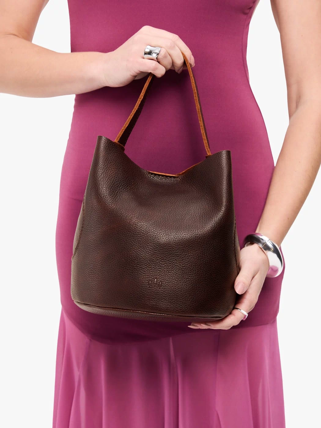 Coldbrew*Large | Model holding symmetrical bucket bag with handle, latch closure, and removable crossbody strap