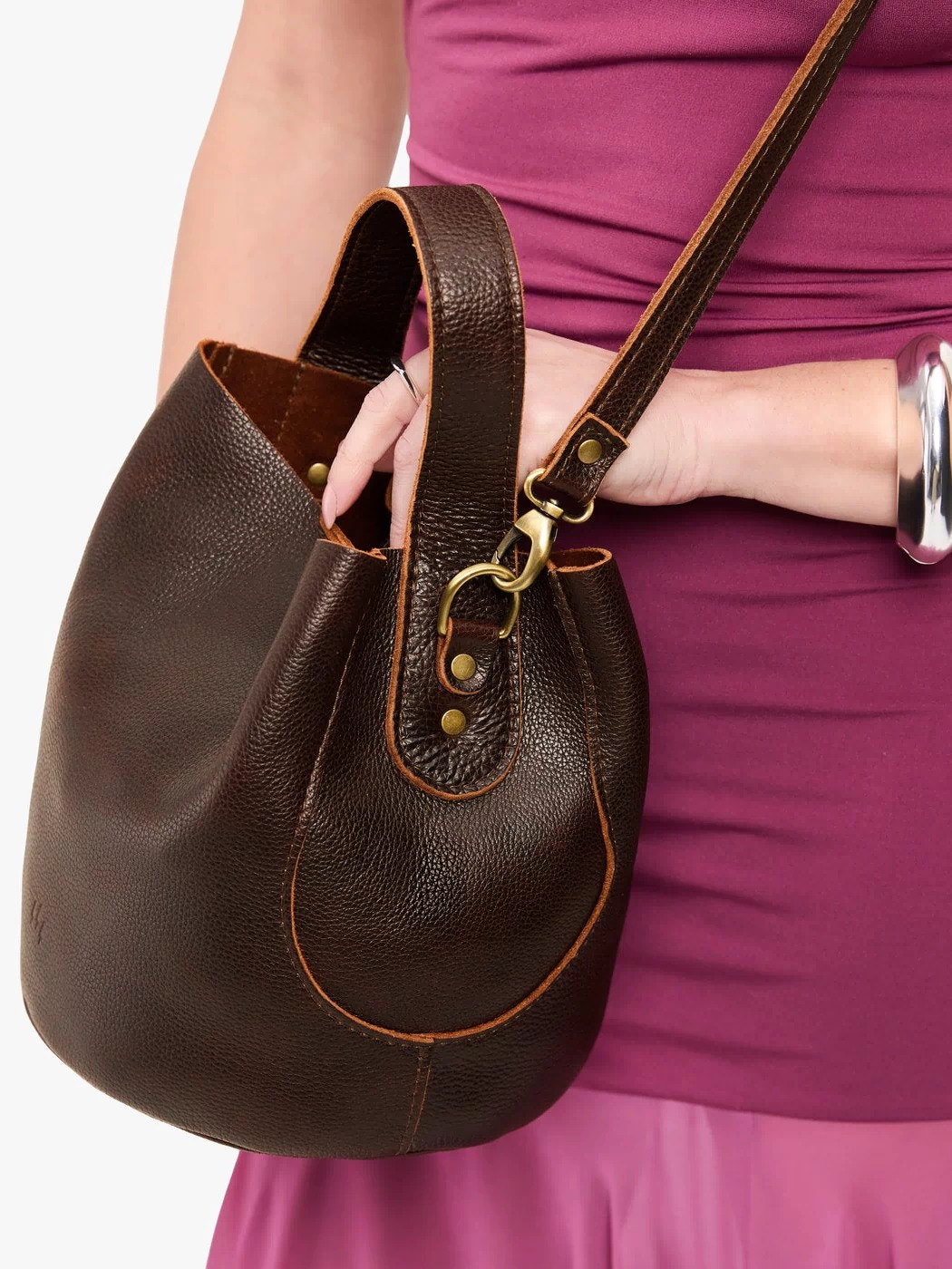 Coldbrew*Large | Model holding symmetrical bucket bag with handle, latch closure, and removable crossbody strap
