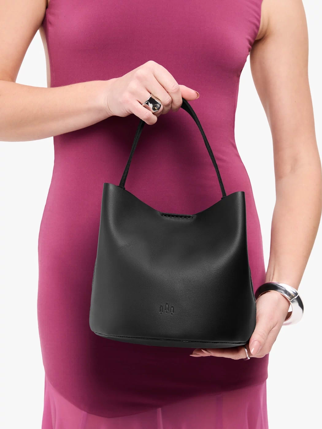 Black*Small | Model holding symmetrical bucket bag with handle, latch closure, and removable crossbody strap