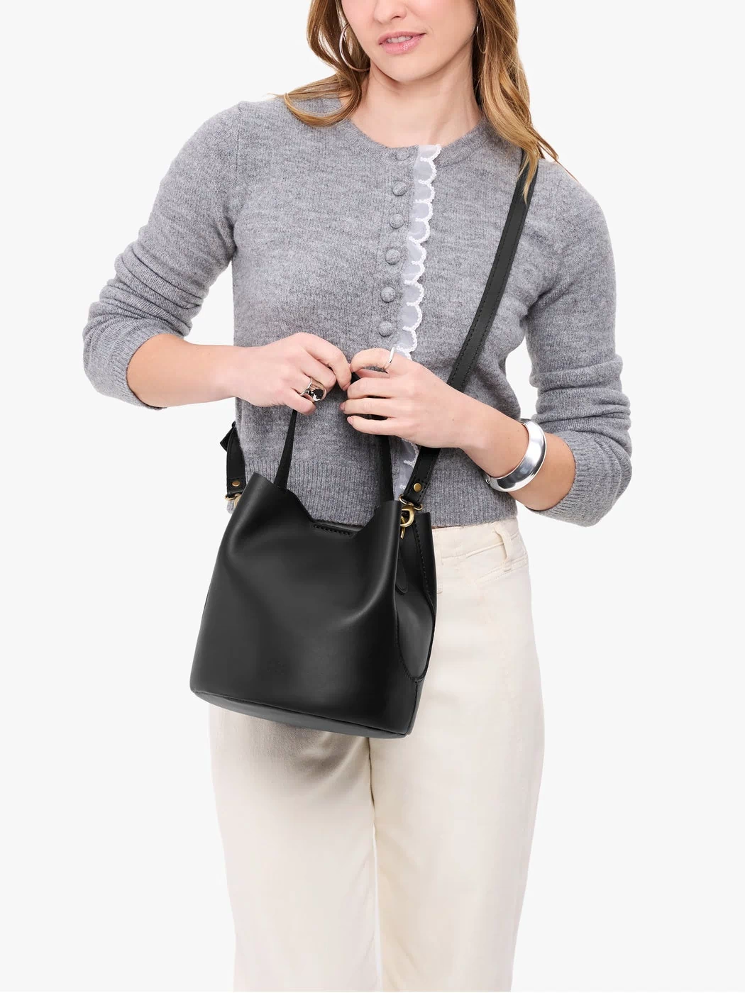 Black*Large | Model holding symmetrical bucket bag with handle, latch closure, and removable crossbody strap
