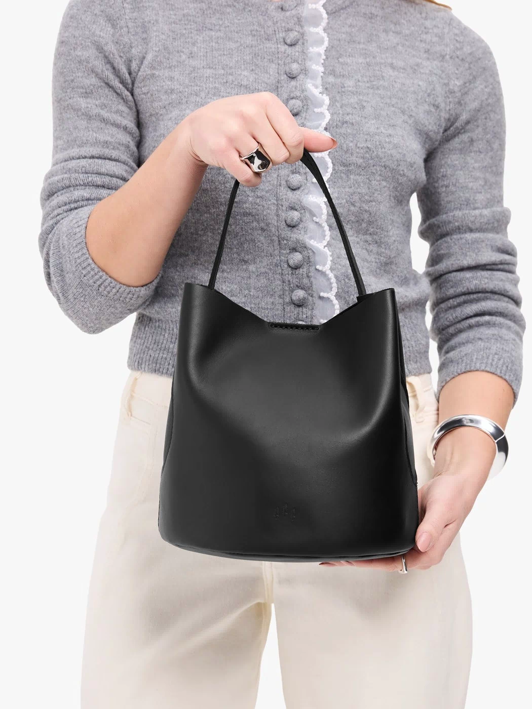 Black*Large | Model holding symmetrical bucket bag with handle, latch closure, and removable crossbody strap