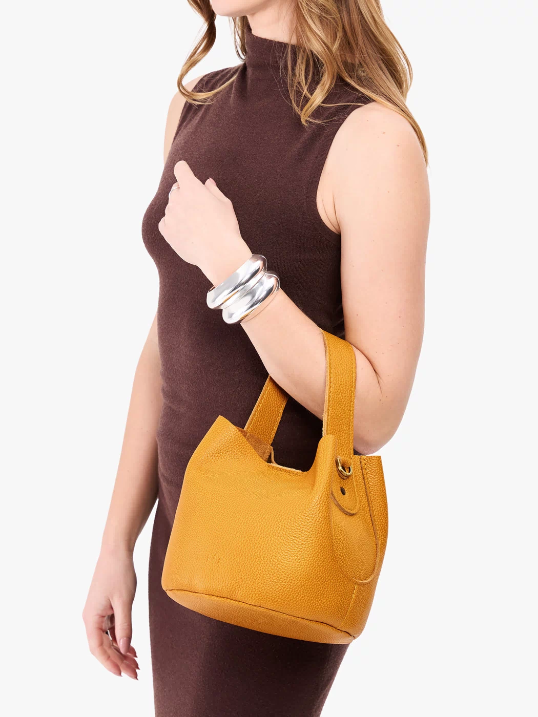 Sunshine*Small | Model carrying symmetrical bucket bag with handle, latch closure, and removable crossbody strap