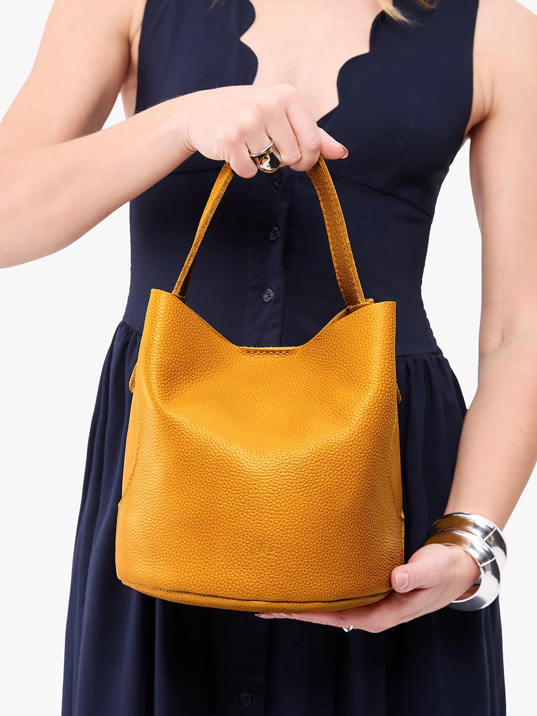 Sunshine*Large | Model holding symmetrical bucket bag with handle, latch closure, and removable crossbody strap