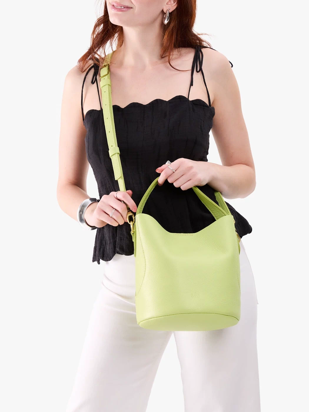 Shadow Lime*Large | Model holding symmetrical bucket bag with handle, latch closure, and removable crossbody strap