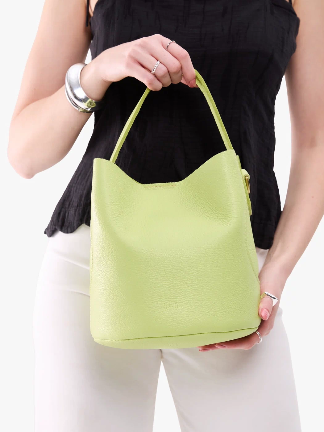 Shadow Lime*Large | Model holding symmetrical bucket bag with handle, latch closure, and removable crossbody strap