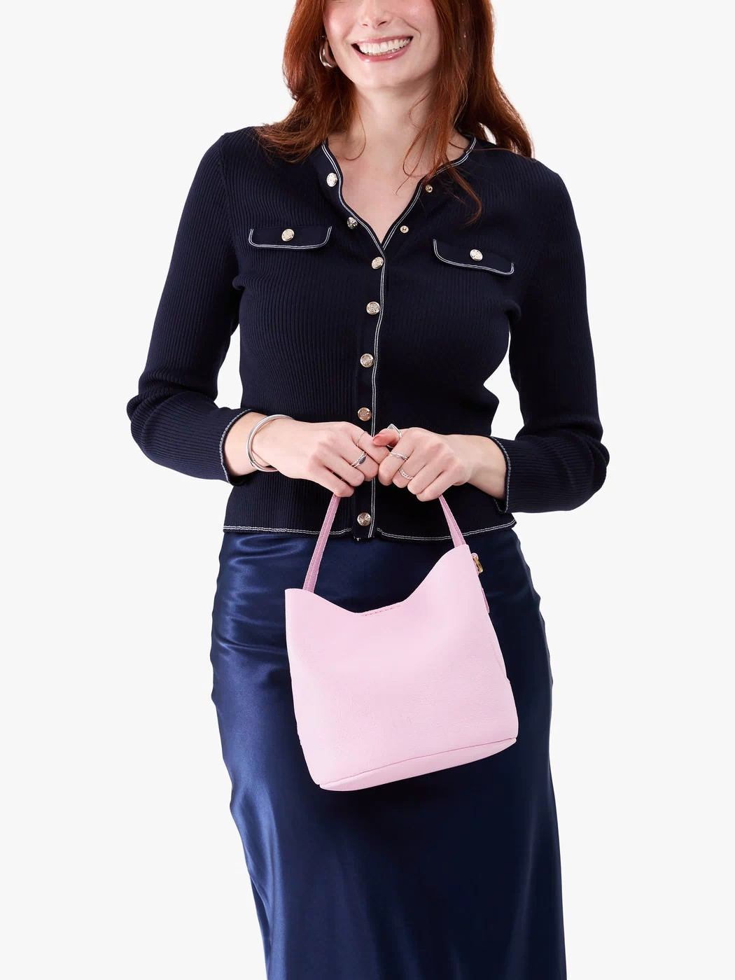 Pinkaboo*Small | Model holding symmetrical bucket bag with handle, latch closure, and removable crossbody strap