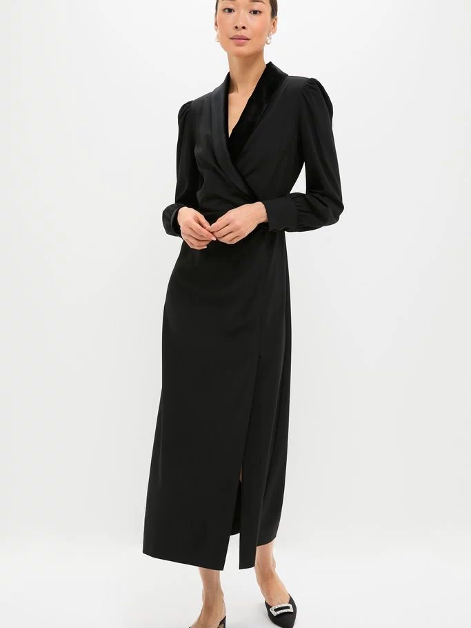 Woman in a classic Black Long Sleeve Mariella Midi Dress with puffed shoulders and side slit, pairing effortless elegance with fun, high-end style, featuring velvet trim and blouson sleeves.