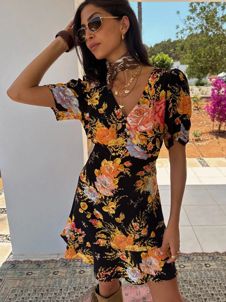 Black Sofia Mini Tea Dress with orange floral print and frilled hem, designed in London for a vacation.