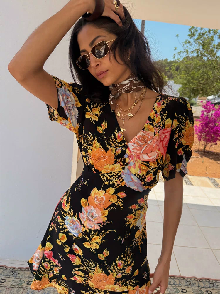 Black Sofia Mini Tea Dress with a vibrant yellow and pink rose print, V-neckline and frill hem.