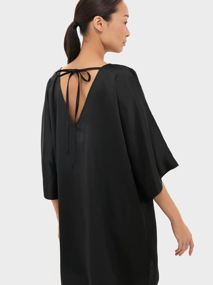 Black Satin Diane Mini Dress featuring a classic, effortless silhouette with a V-shaped back and kimono sleeves. Perfect for fun, high-end events.