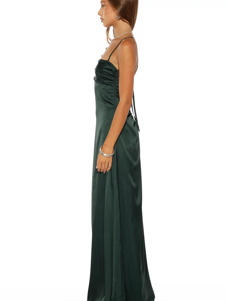 Side view of an emerald satin maxi dress with ruched bodice, spaghetti straps, and tie-back detail