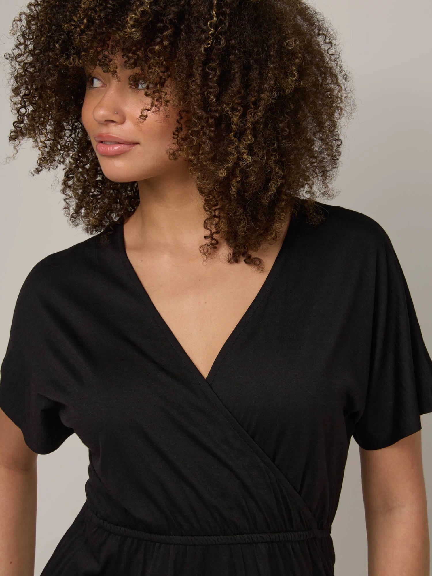 Model wearing Brooklyn Reversible Dress in Black. Brooklyn Reversible Dress is a merino wool short sleeve, reversible, knee length fit & flare dress with pockets available in sizes XS-3X Regular, XS-XL Long.