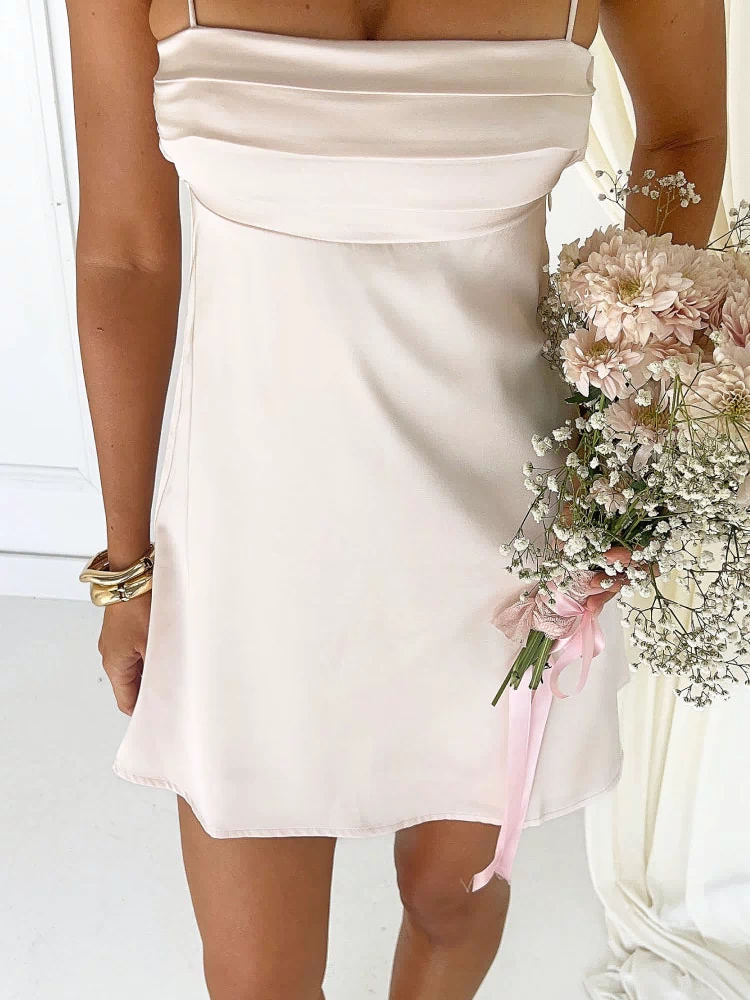 Close-up of the cream satin mini dress showing the draped bust detail and thin spaghetti straps