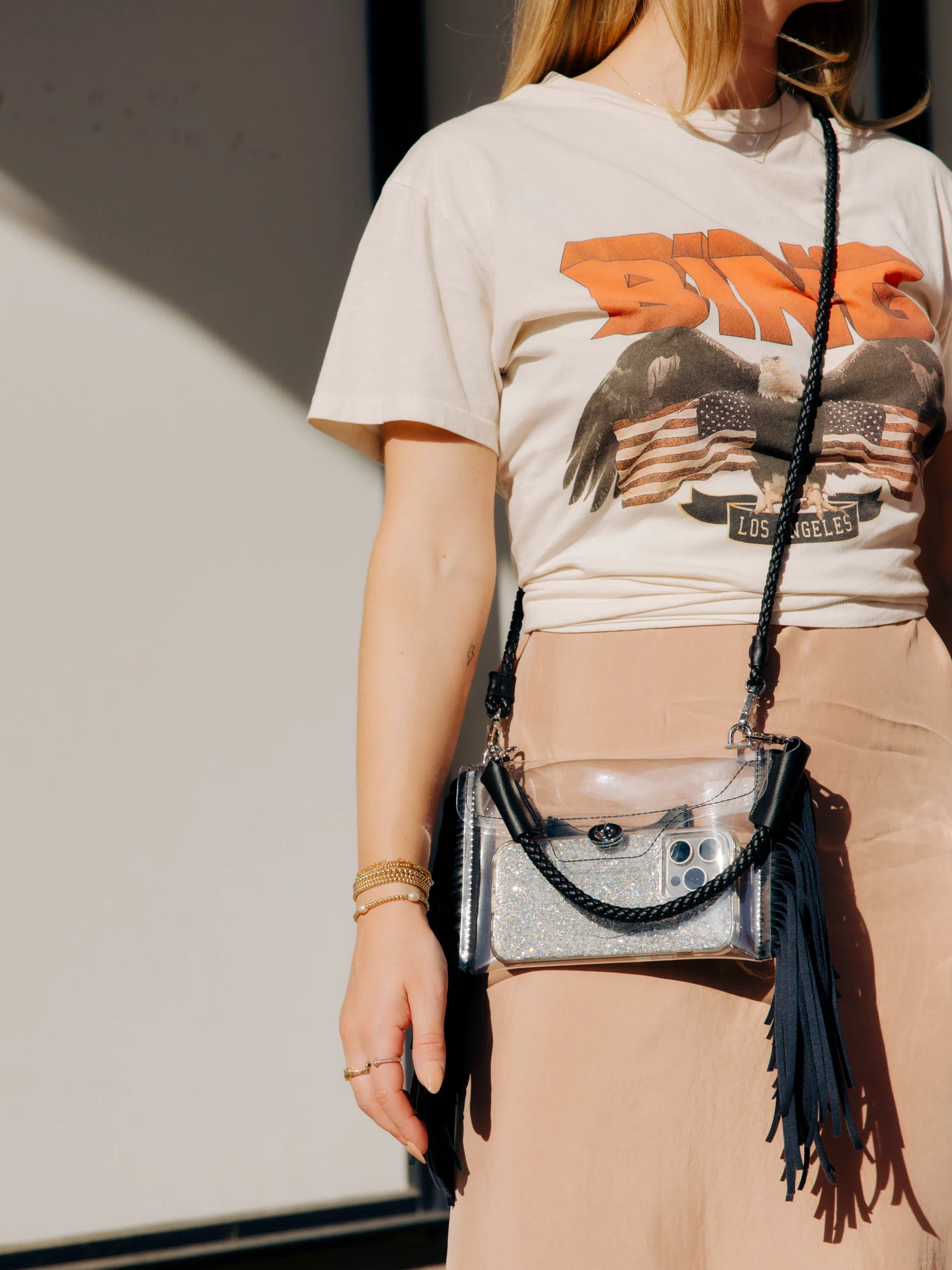 Woman wearing a concert t-shirt over a dress with a black Clear Fringe Crossbody - Margo Paige