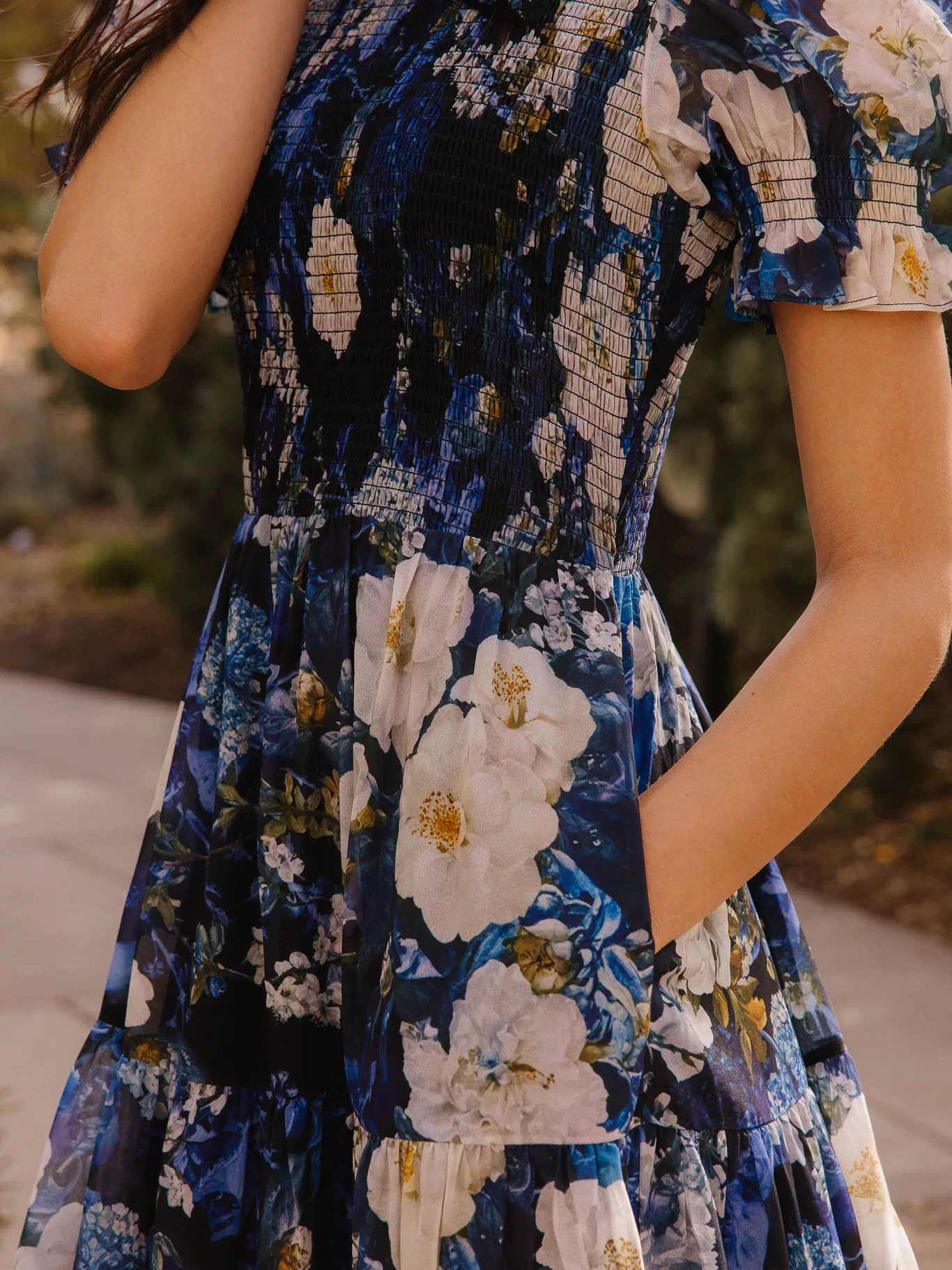 Girl in blue dress in front of trees
