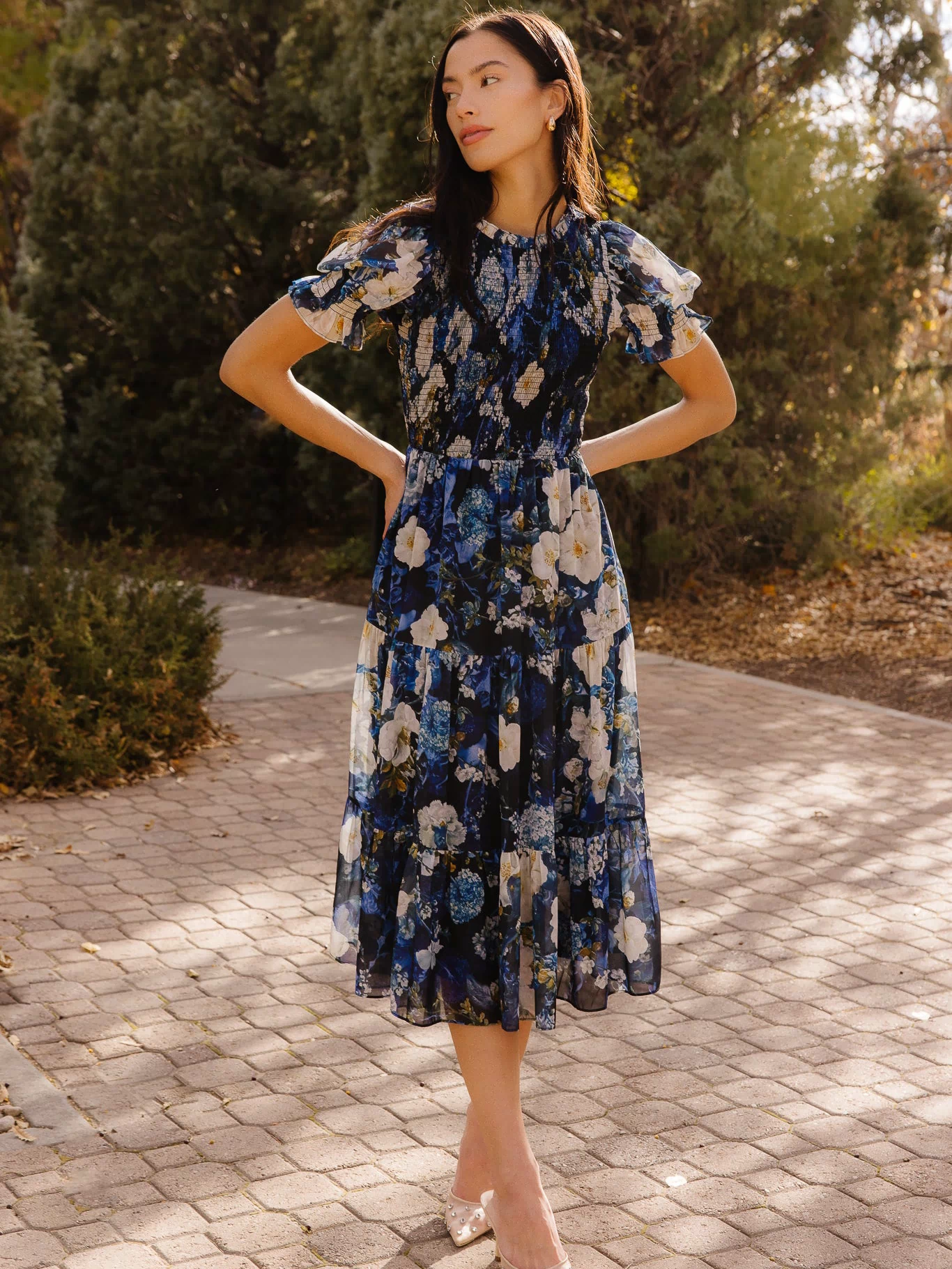 Girl in a blue dress in front of trees