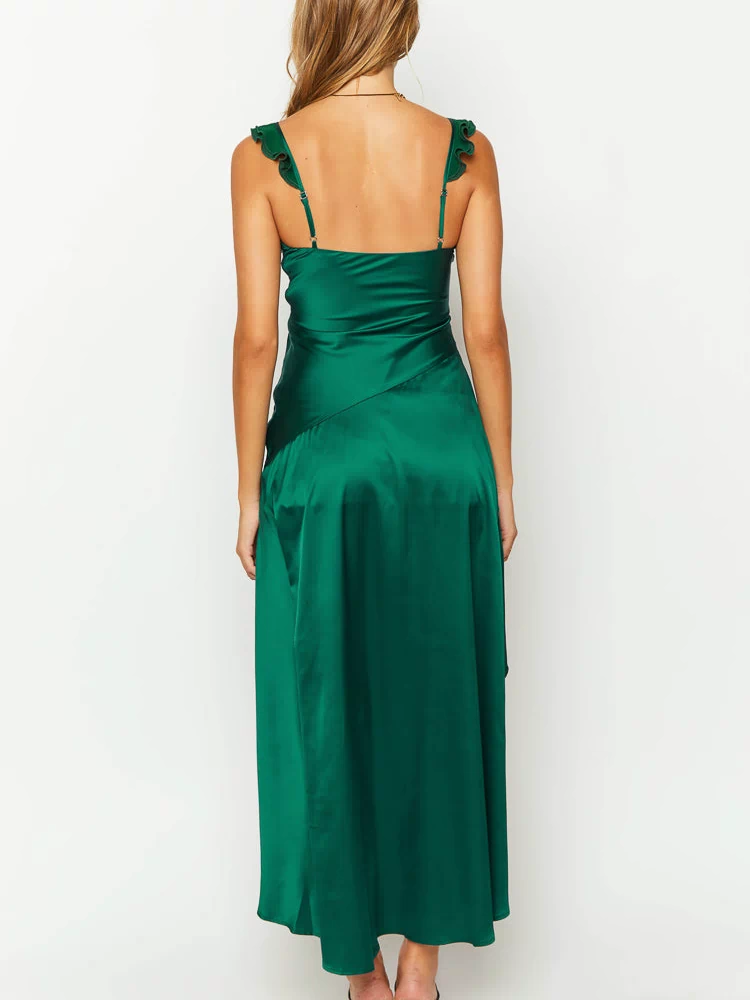 Rear view of a green satin maxi dress with ruffled spaghetti straps and a diagonal seam detail on the flowy skirt