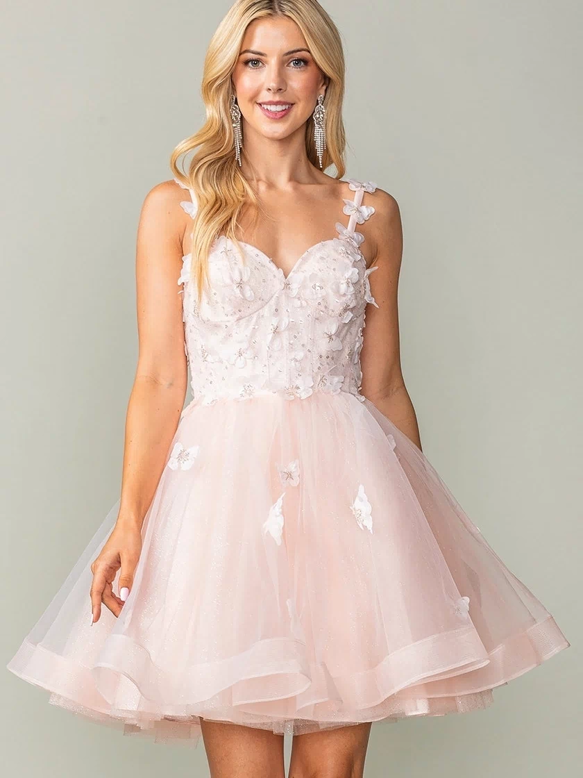 Wearing the Lace-Up Short Butterfly Homecoming Dress 3369, a woman smiles against a plain background. The light pink, sleeveless knee-length dress features tulle, floral appliqués, and delicate 3-D butterflies.