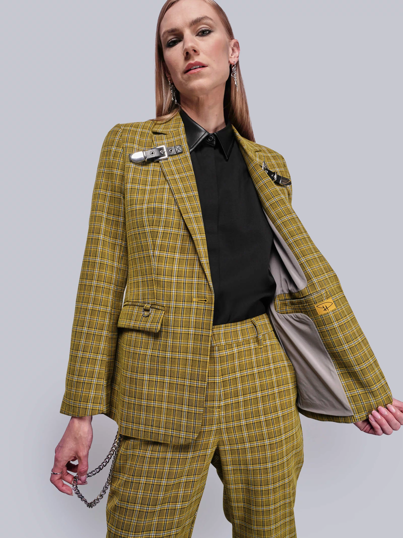 S=Person wearing a yellow plaid suit against a plain background