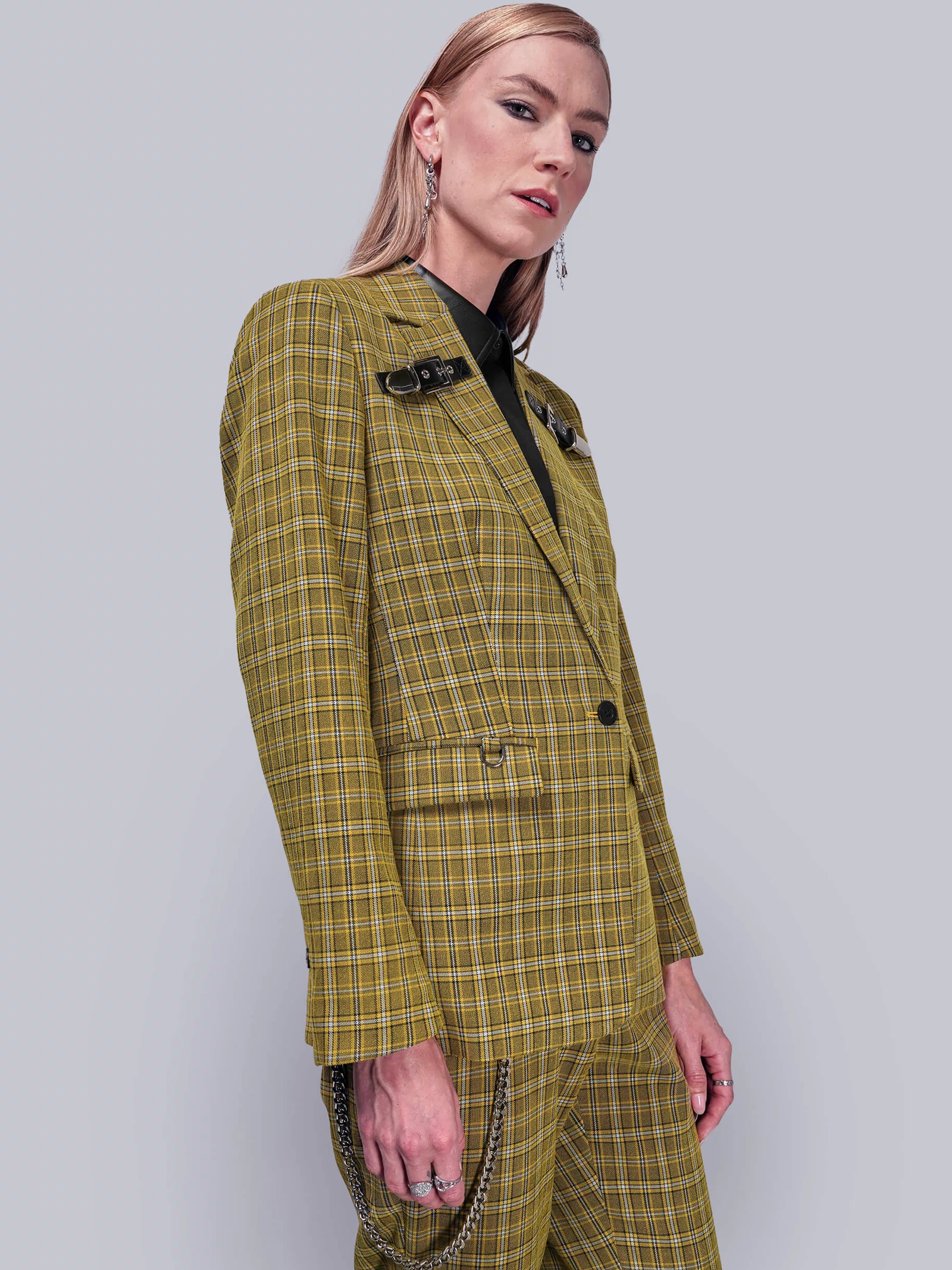 S=Side view of person wearing a yellow plaid suit against a plain background
