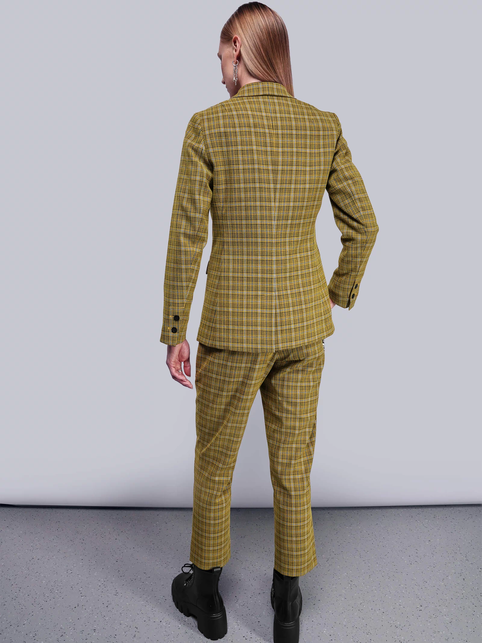 S=Back view of person wearing a yellow plaid suit against a plain background
