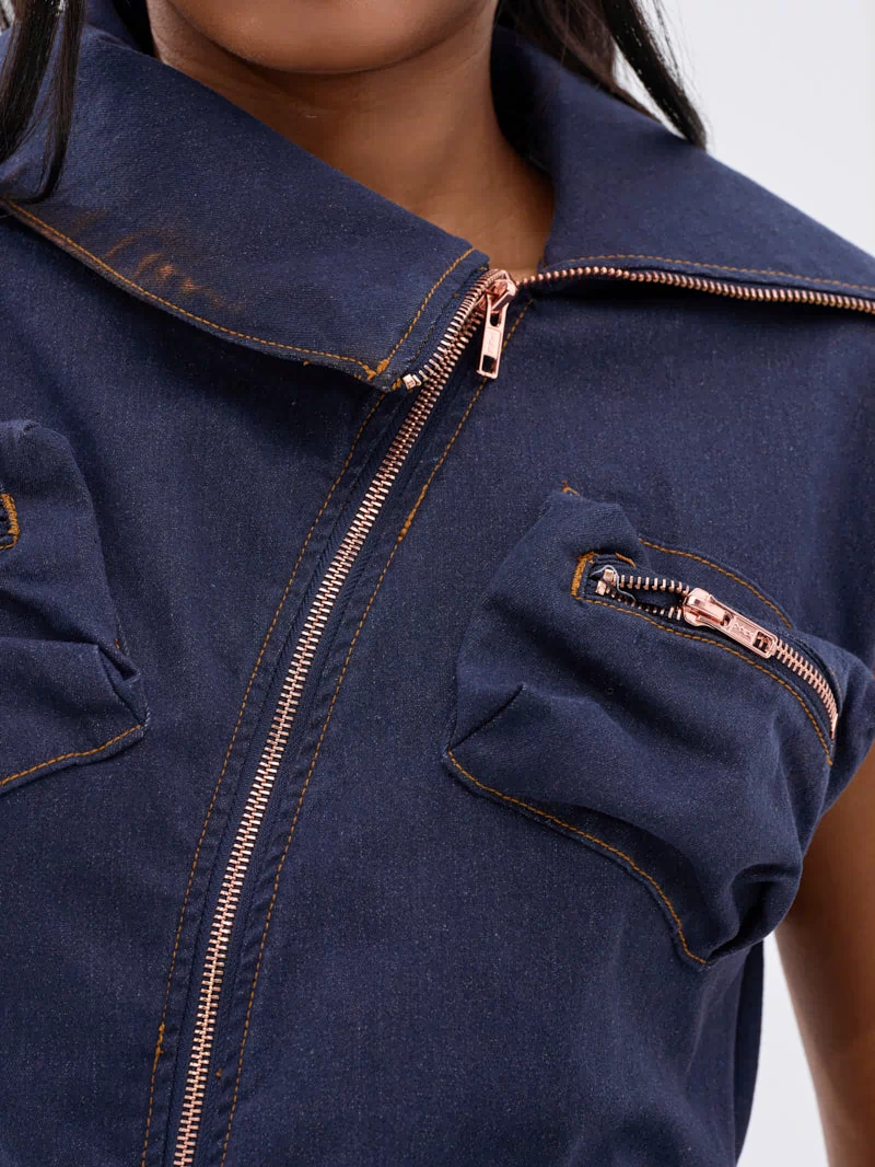 Close-up of a person wearing the DONT MESS WITH ME COLLARED DENIM MAXI DRESS, featuring a dark wash, copper zippers, utility pockets, two zippered chest pockets, and a large collar. Only the lower face and upper torso are visible.