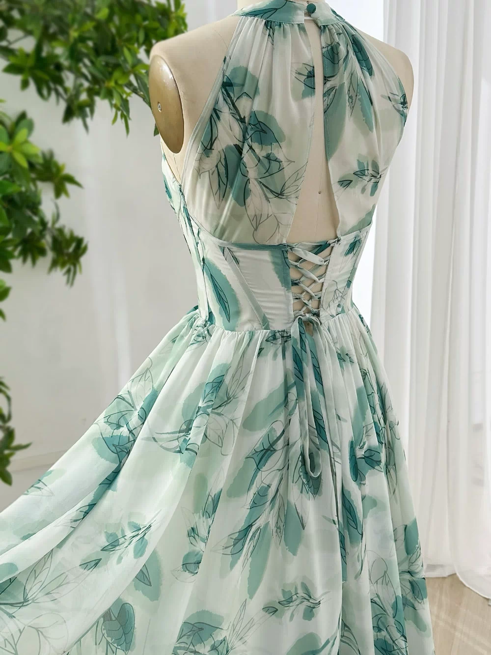 Backless lace up chiffon maxi dress with halter neckline and green botanical leaf print for summer wedding reception styling